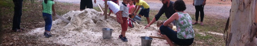 Children playing with a pile of sand in a park